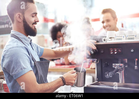 Barista dampfenden Milch im café Stockfoto