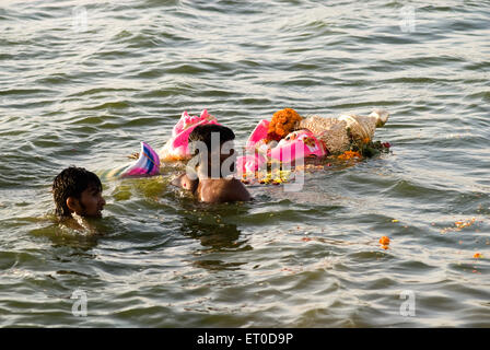 Menschen, die Idol von Lord Ganesh mitten im Teich auf Ganpati Festival; Muthannankulam; Coimbatore; Tamil Nadu Stockfoto