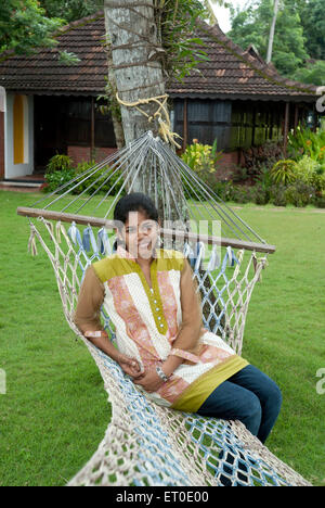 Frau in Hängematte im Erbe Lake Resort sitzen; Kuttanad; Alleppey Alappuzha; Kerala; Indien Herr #777 L Stockfoto