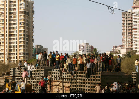 Menschenmenge auf Baumaterial stehend, Versova, Andheri, Bombay, Mumbai, Maharashtra, Indien, Asien Stockfoto