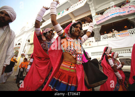 Gruppe von Nomad Frauen gekleidet in bunte Kleidung außerhalb Sachkhand Saheb Gurudwara in Nanded tanzen; Maharashtra; Indien nicht Herr Stockfoto