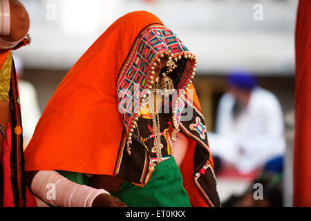 Nomad Frau, gekleidet in ihrer traditionellen bunten Kleidung draußen Sachkhand Saheb Gurudwara in Nanded Stockfoto