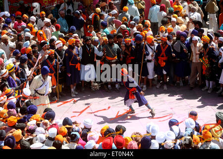 Nihang oder Sikh Krieger Durchführung Stunts mit Waffe in während Hola Mohalla feiern bei Anandpur Sahib in Rupnagar Stockfoto