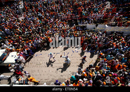 Nihang oder Sikh Krieger Durchführung Stunts mit Holzschwertern in während Hola Mohalla feiern bei Anandpur sahib Stockfoto