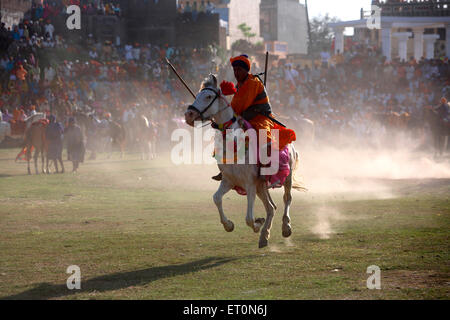 Nihang oder Sikh Krieger mit Speer und Gewehr Reiten auf Pferd während Hola Mohalla Festivals bei Anandpur Stunts ausführen Stockfoto