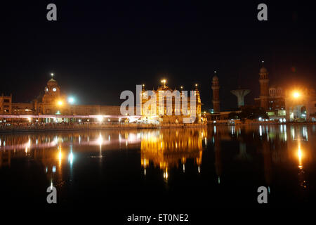 Beleuchteten Harmandir Sahib oder Darbar Sahib oder goldenen Tempel und Türme von Ramgarhia Bunga Spiegelbild im See in Amritsar Stockfoto