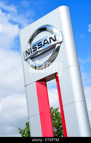 Nissan Firmenlogo und Markenhinweis für Autohändler vor dem neuen Autohaus mit Service-Center in East London, England Stockfoto