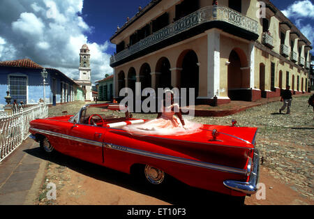 Junges Mädchen gekleidet für Quinceanera oder Quitte, die Feier des fünfzehnten Geburtstag eines Mädchens in Trinidad, Kuba, Karibik. Klassische rote 1959 schönen Chevy Cabrio auf Kopfsteinpflaster von Trinidad Kuba ein altes koloniales Dorf Stockfoto