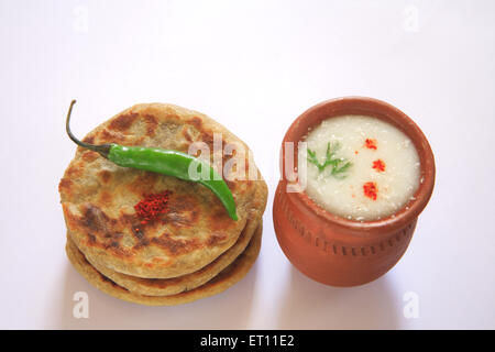 Bhakri Jowar Brot mit grünen Chilis und Buttermilch in irdenen Topf auf weißem Hintergrund Stockfoto