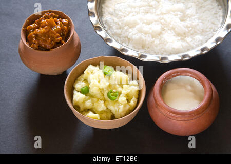 Indische Mittagessen Pakhala Reis in Schale und Gurke Maische Kartoffel mit Chili-Joghurt in irdenen Topf schwarzen Hintergrund Stockfoto