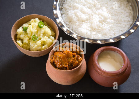 Indische Mittagessen Pakhala Reis in Schale und Gurke Maische Kartoffel mit Chili-Joghurt in irdenen Topf schwarzen Hintergrund Stockfoto