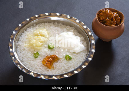 Indische Mittagessen Pakhala Reis Gurke Maische Kartoffel mit Chili und Joghurt in Stahl Schüssel mit Gurke in irdenen Topf schwarzen Hintergrund Stockfoto