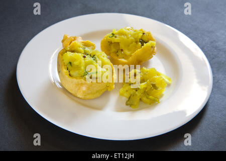 Indisches Fastfood gebraten Batata Kartoffel Vada serviert mit Papaya Chutney in Platte auf schwarzem Hintergrund 13. Mai 2010 Stockfoto