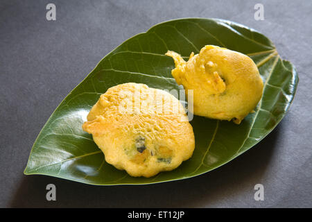 Indisches Fastfood gebraten Batata Kartoffel Vada serviert im Blatt auf schwarzem Hintergrund 13. Mai 2010 Stockfoto