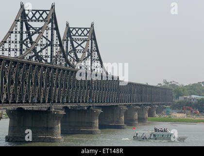 Dandong, LIAONNG Provinz, CHINA. 27. Mai 2015. Koreanischen, japanischen und koreanischen Touristen besuchen den Yalu wie Handel mit Nordkorea (Hintergrund) und auf die Brücke der Freundschaft in Dandong, Chinas größere Grenzstadt mit Nordkorea in der Liaoning Provinz, China am 27. Mai 2015 weiter. China bleibt wichtigster Verbündeter Nordkoreas, Bereitstellung von Pyongyang mit den größten Teil seiner Nahrung und Energie liefert und umfasst mehr als 60 Prozent seiner gesamten Handelsvolumen. Wirtschaftliche Abhängigkeit Nordkoreas von China wächst weiter durch internationale Sanktionen, wie durch die bedeutenden Handel imbalan Stockfoto