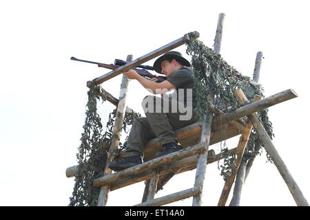 Ein Jäger mit Gewehr auf einem Hochsitz Stockfoto