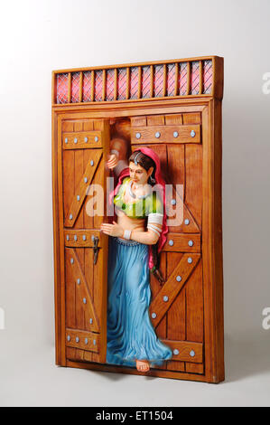 Tonfigur; Statue des Rajasthani junges Mädchen peeping aus halb geöffnete Tür Stockfoto