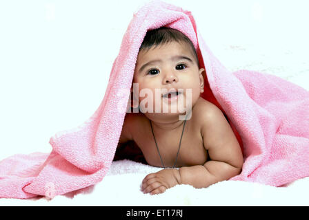 Indische baby Junge Kind Hals Amulett Kopf mit rosa Handtuch liegend auf Bauch Magen suchen auf weißem Hintergrund Herr Nr. 364-Rmm 178217 abgedeckt Stockfoto