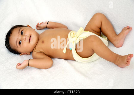 Baby boy in Windel Windeln tragen Amulett lag auf dem Rücken auf weißem Hintergrund Herr #784 F Stockfoto