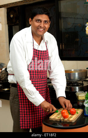 Indische mann Schürze kochen schneiden Tomaten Schneidbrett Küche aus Holz - HERR Nr. 364 Stockfoto