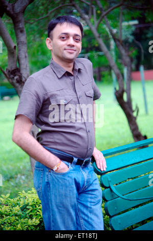 Indische jungen Mann, der mit der Hand in Blue Jeans Tasche im Garten - Herr Nr. 364-Rmm 179837 Stockfoto