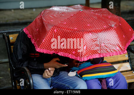 Junges Paar genießen Monsun in einen Regenschirm Mumbai Indien Asien Stockfoto