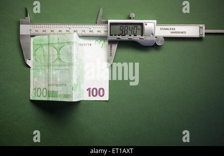 Konzeptuelle Komposition Geld Abwertung, symbolisch zeigte mit Schiebe-Bremssattel hundert Euro Messen vertreten. Stockfoto