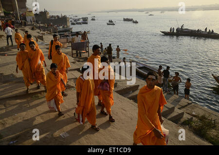 Studenten des Sanskrit Gurukul in Safran-Kostüm zu Fuß auf Varanasi Ghat Uttar Pradesh, Indien Stockfoto