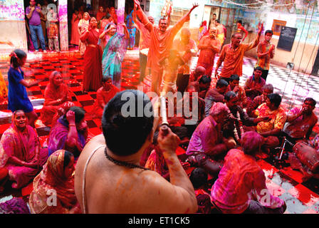 Priester spielen Holi mit Anhängern in Bande Shyamji Tempel; Jodhpur; Rajasthan; Indien NOMR Stockfoto