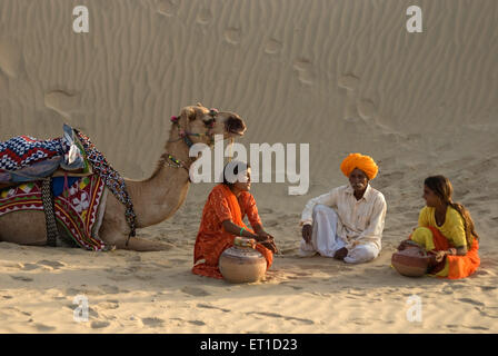 Frau und Mann mit Kamel Rast in der Wüste von Khuhri; Jaisalmer; Rajasthan; Indien NOMR Stockfoto