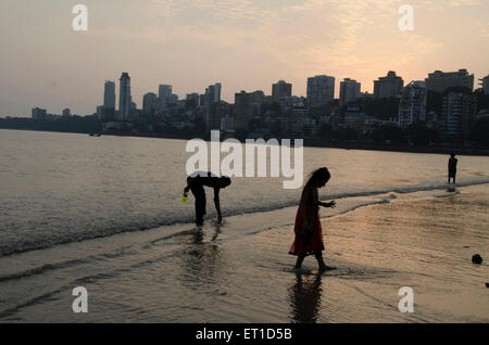 Kinder sammeln etwas im Meer bei Girgaon Chowpatty Mumbai Indien Asien Stockfoto