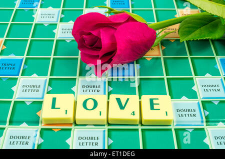 Das Wort Liebe auf einem Scrabble-Brett mit einer roten rose Stockfoto