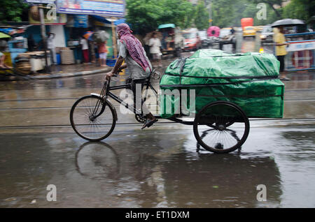 Mann reitet Dreirad mit Gepäck auf Straße in Kalkutta in West Bengal Indien Asien Stockfoto