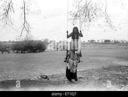 Frauen auf Schaukel genießen das Schwingen; Maharashtra; Indien Stockfoto