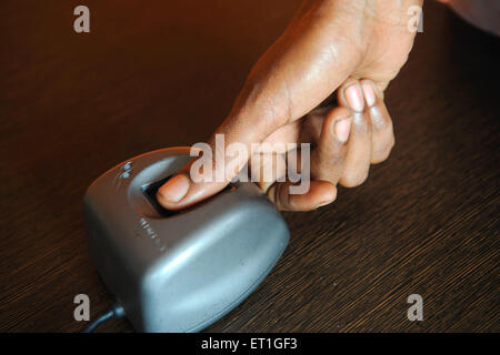 Ländliche Dame mit Thumbpress Gerät in Bank von Ngo Kshtriya Gramin financial Services IFMR-Stiftung; Thanjavur Stockfoto