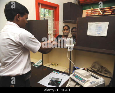 Ländliche Dame mit Freiwilliger in der Bank von NGO Kshtriya Gramin Financial Services von IFMR-Stiftung Thanjavur Tamil Nadu Indien Asien Indisch Asiatisch Stockfoto