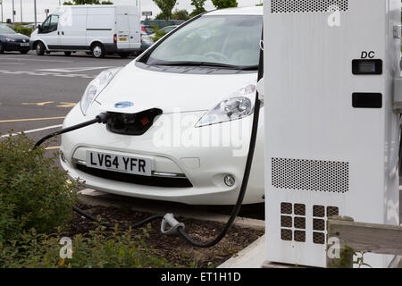 Ein Nissan Leaf Elektroauto wird aufgeladen bei Cobham Services auf der M25, Surrey, England, UK Stockfoto