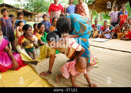 Ho Stämme Frauen spielen huckepack und Austausch von medizinischen Informationen; Chakradharpur; Jharkhand; Indien nicht Herr Stockfoto