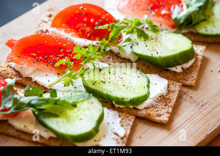 Gesunde Ernährung-Thema. Baguettes und Sandwiches. Finnische Roggen Knäckebrot, Weichkäse, Gurken, Tomaten, Petersilie und Pfeffer Stockfoto