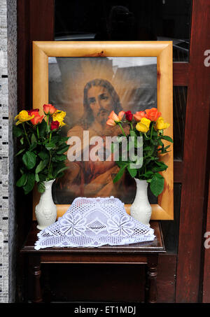 Gerahmte Bild von Jesus, umgeben von Blumen vor einem Haus in Buncrana, County Donegal, Irland am fest von Corpus Christi. Stockfoto