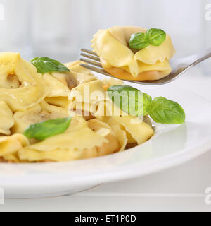 Italienische Küche, die Tortellini Nudeln Nudeln Essen mit einer Gabel und Basilikum Stockfoto