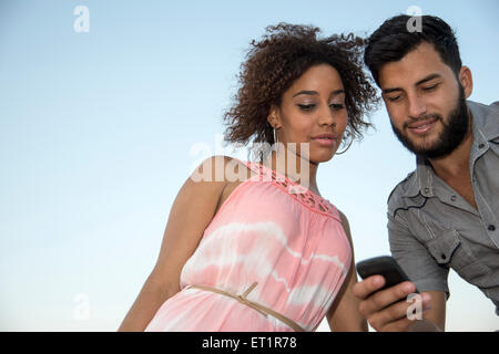 Junges Paar mit Handy Stockfoto