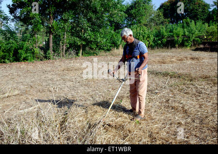 Bauer mit Grass schneiden Maschine Konkan Maharashtra Indien Herr #556 Stockfoto