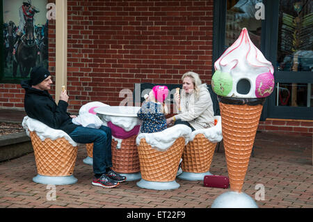 Familie von drei essen Eiscreme, sitzen in den übergroßen "Zapfen" bei Daylesford, Victoria Stockfoto