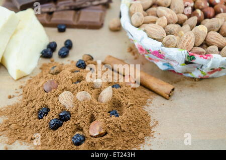 Kakao, Schokolade, Mandeln, Zimt und Rosinen auf einem Holztisch Stockfoto