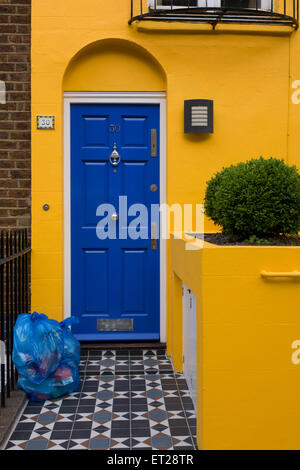 Gelbes Haus mit blauen Tür und blau recycling Taschen vor Haustüre, London. Stockfoto