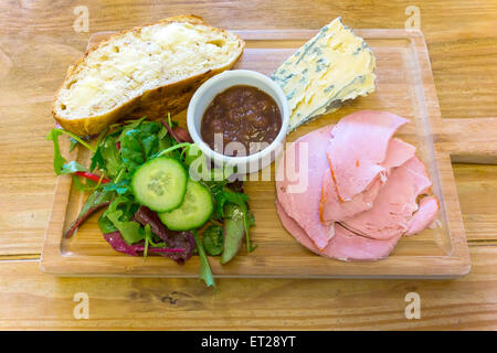 Eine leckere traditionelle Pflüger Mittagessen von Ham Blue Cheese Käse Salat Gurke und Brot und Butter in einem Café in North Yorkshire Stockfoto