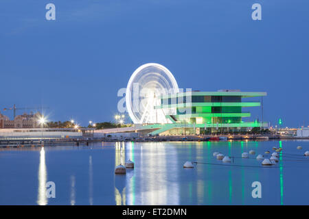 Americas Cup Gebäude und Riesenrad im Hafen von Valencia, nachts beleuchtet Stockfoto