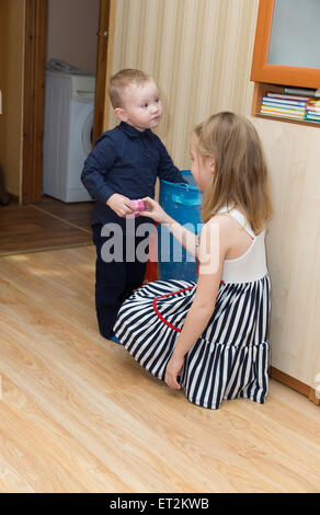 der kleine Junge spielt mit mehr ältere Schwester Stockfoto