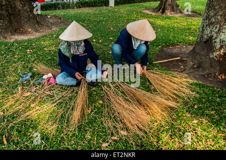Gärtner machen Besen für die Reinigung von eines Parks. Ho-Chi-Minh-Stadt (Saigon), Vietnam Stockfoto